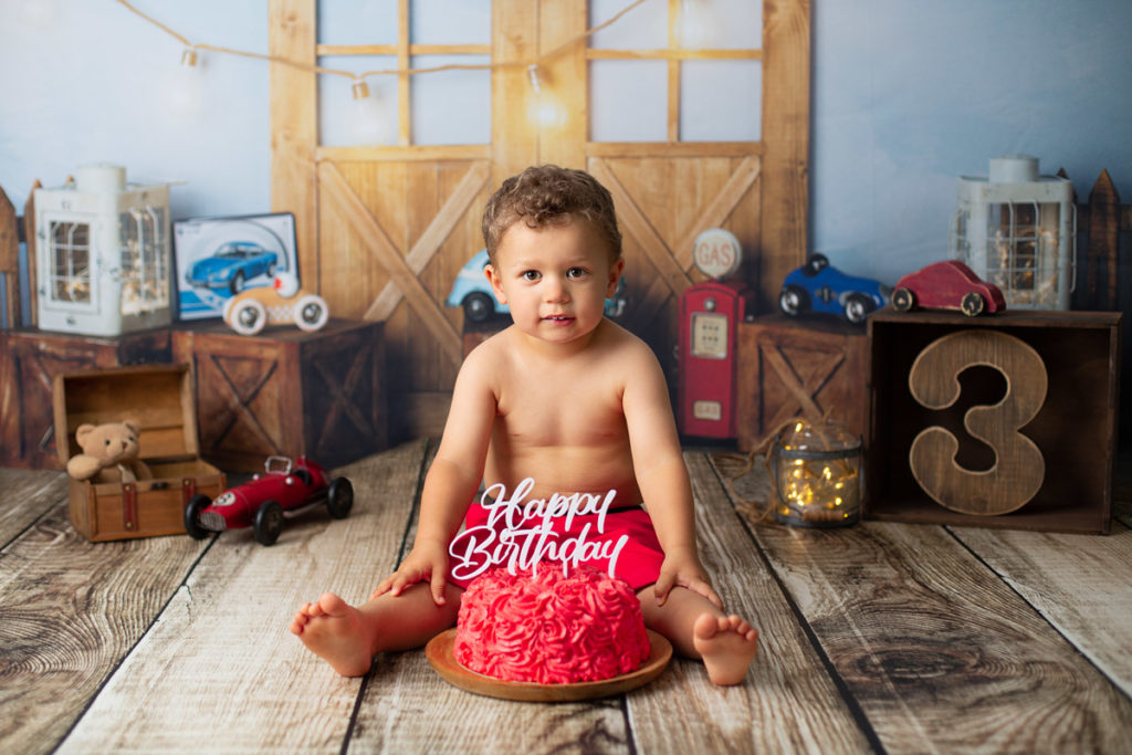 Petit garçon mangeant du gâteau rouge pour ses 3 ans